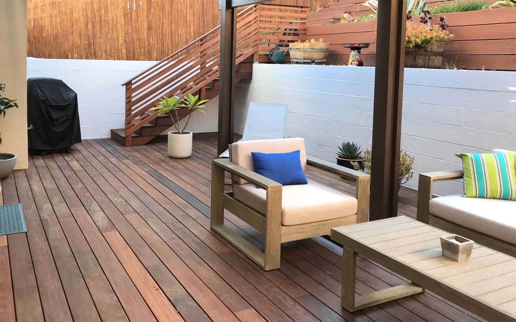 downstairs deck seating area with stairs and plants